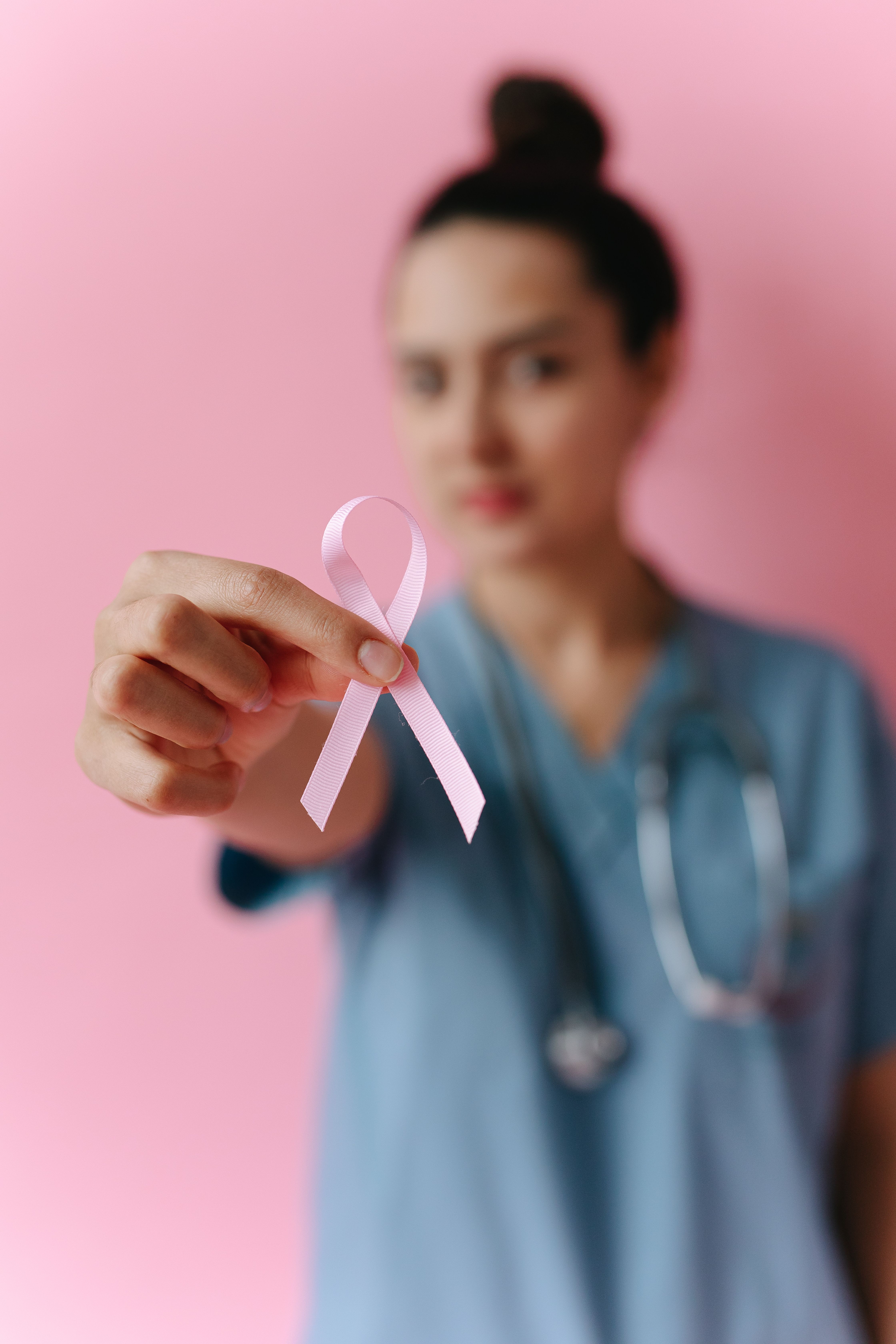 Healthcare professional holding a pink ribbon